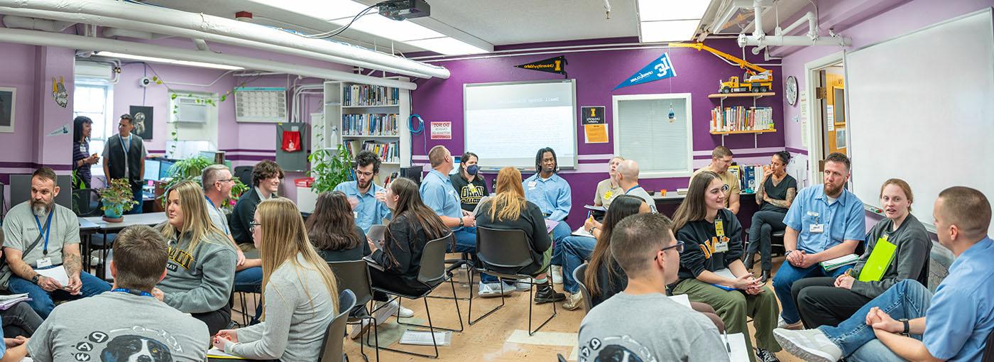 Incarcerated students and students from the Moscow campus have a classroom discussion.