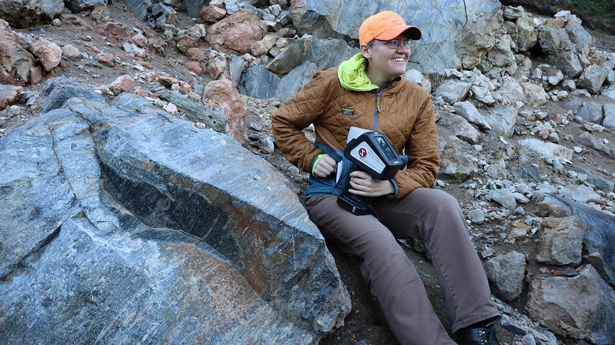 Erika Rader sits on a pile of rocks at Crater Lake, Oregon.